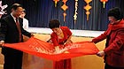 Liu Yuhua (C) performs magic with audiences during a celebration of the Chinese Spring Festival held by the Beijing Municipal Association for Overseas Chinese Affairs, in Vienna, capital of Austria, Jan. 25, 2012.