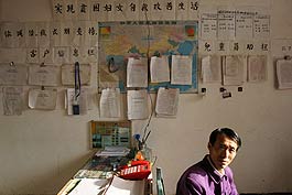 He Songlin has transformed his home to an office since he was hired as the credit clerk for a Xixiang County women's association. His wall is plastered with client information, supporting policies for poor families and children and lists of good credit client.