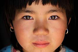 Li Jin, 9, lives on the Loess Plateau, lingered with drought and not suitable for human survival as per the World Food Program. Li and other children could seldom clean their faces or wash clothes. But through her often-muddied face, her clear eyes sparkle, reflecting a heart pure and hopeful for a bright future.