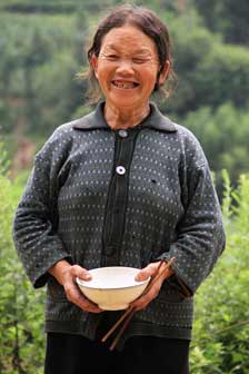 Empty bowl in hand, the Xixiang woman beamed for the camera and said happiness was not necessarily resulted from material possessions.