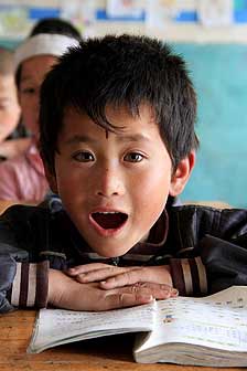 A boy is reading text full-mouthed in a rural primary school in Ningxia. His exaggerated mouth and amber eyes reveals his brimming energy.
