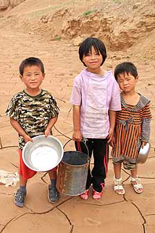 These children are accustomed to drought in Northwestern China. The containers are not for water but for picking medlar and earning pocket money.