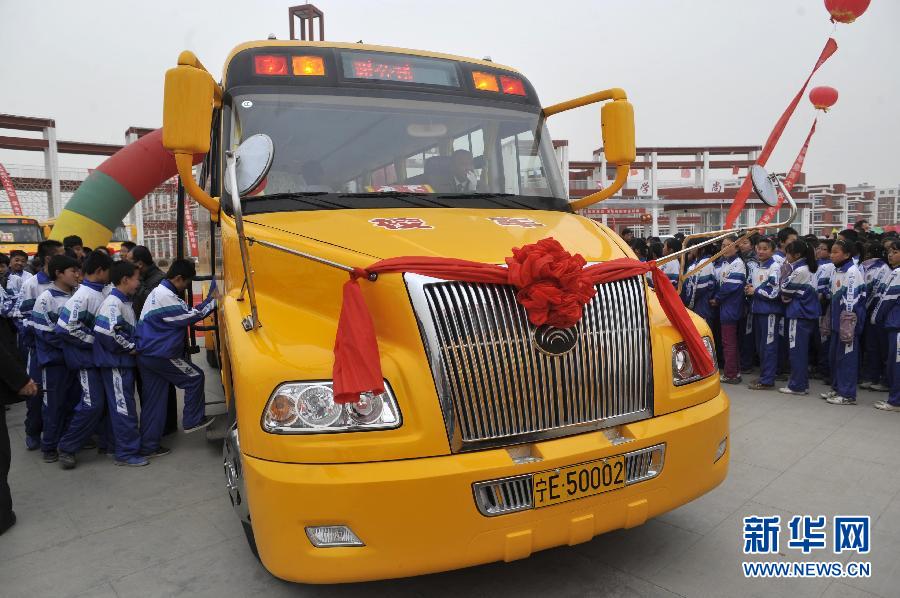 Students get on board at a ceremony to mark the beginning of operations for Zhongwei No.6 Middle School&apos;s new American-style bus fleet.