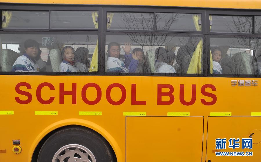 Students of Zhongwei No.6 Middle School in Shapotou District, Zhongwei City, northwest China&apos;s Ningxia Hui Autonomous Region, ride one of the school&apos;s new American-style school buses on Feb. 23, 2012. 