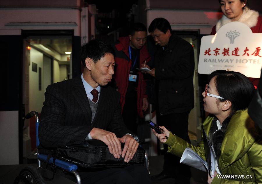 Wang Shuming (Front L), a member of the 11th National Committee of the Chinese People's Political Consultative Conference (CPPCC) from northeast China's Jilin Province, speaks to a journalist as he arrives in Beijing, capital of China, March 1, 2012.