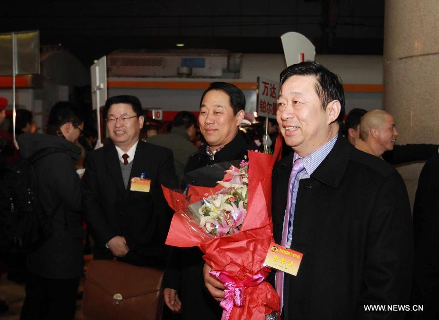 Wang Chaobin (Front R), a member of the 11th National Committee of the Chinese People's Political Consultative Conference (CPPCC) from central China's Henan Province, arrives in Beijing, capital of China, March 1, 2012.