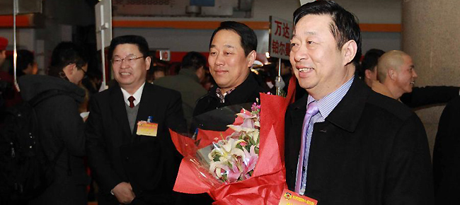 Wang Chaobin (Front R), a member of the 11th National Committee of the Chinese People's Political Consultative Conference (CPPCC) from central China's Henan Province, arrives in Beijing, capital of China, March 1, 2012.