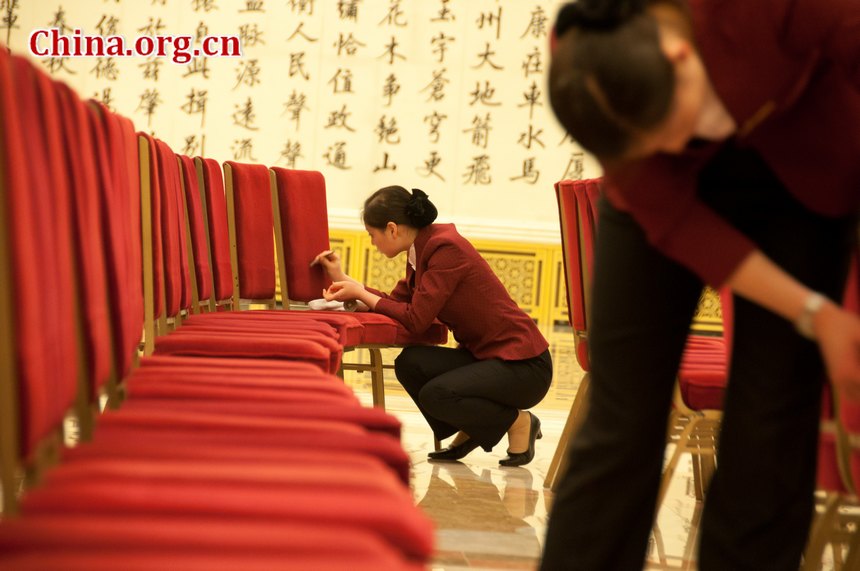 Staff members of the Great Hall of the People tidy the chairs at the Golden Hall, the venue for important press conference during China's National People's Congress (NPC) and CPPCC sessions on the afternoon of Thursday, March 1, 2012