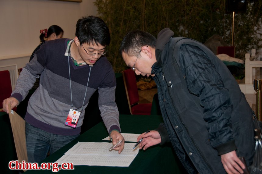 Reporters queue up to get their press cards for the NPC and CPPCC session at the Great Hall of the People in Beijing, China, on the afternoon of Thursday, March 1, 2012