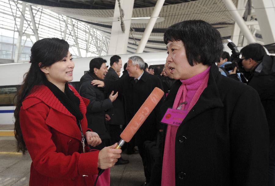 Zhu Guoping (R), a deputy to the Fifth Session of the 11th National People's Congress (NPC) from east China's Shanghai, speaks to a journalist as she arrives in Beijing, capital of China, March 2, 2012. 