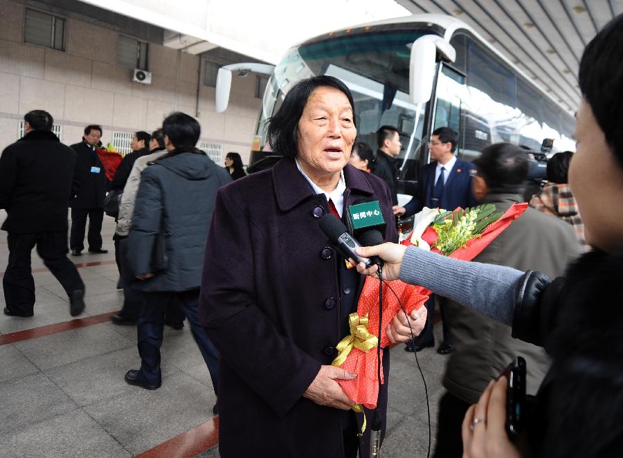 Shen Jilan (C), a deputy to the Fifth Session of the 11th National People's Congress (NPC) from north China's Shanxi Province, speaks to a journalist as she arrives in Beijing, capital of China, March 2, 2012. 