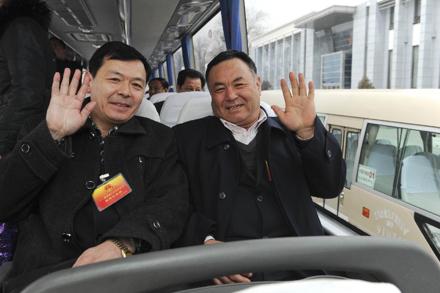 Abdurahman Yasen (R, front), a deputy to the Fifth Session of the 11th National People's Congress (NPC) from northwest China's Xinjiang Uygur Autonomous Region, sits in a bus together with other deputies after their arrival in Beijing, capital of China, March 2, 2012. 