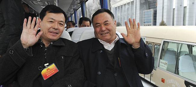 Abdurahman Yasen (R, front), a deputy to the Fifth Session of the 11th National People's Congress (NPC) from northwest China's Xinjiang Uygur Autonomous Region, sits in a bus together with other deputies after their arrival in Beijing, capital of China, March 2, 2012.