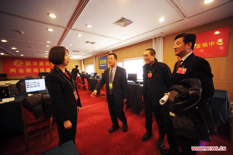 (Famous director Zhang Yimou (2nd R), a member of the 11th National Committee of the Chinese People's Political Consultative Conference (CPPCC), visits the reporting center of Xinhua News Agency prior to the CPPCC session at the Great Hall of the People in Beijing, capital of China, March 3, 2012. 