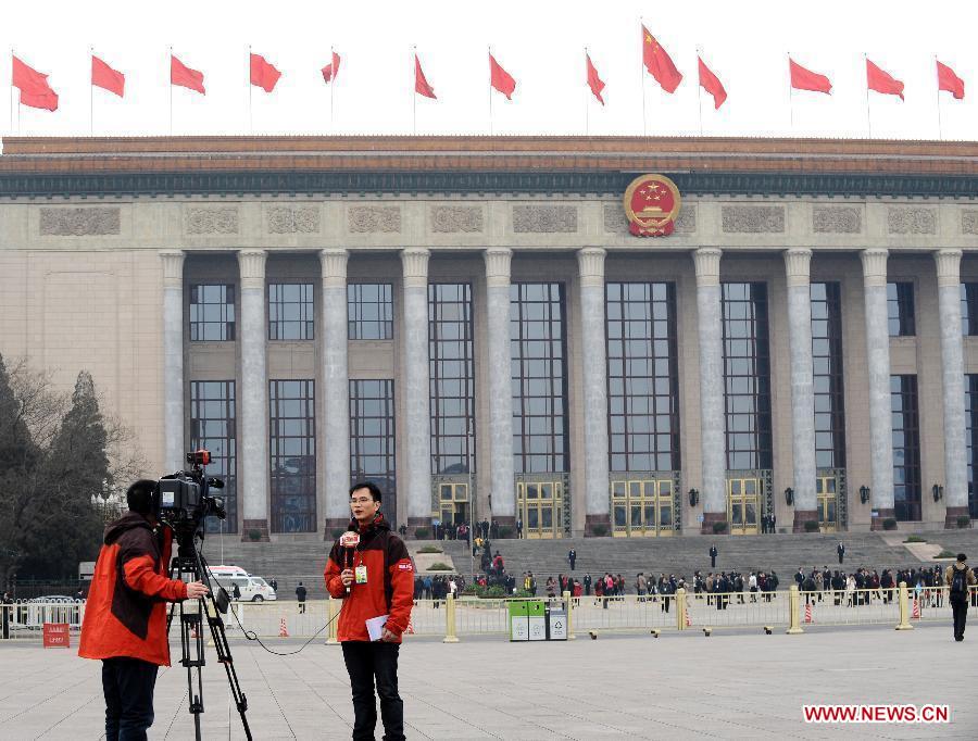 Two journalists to the 11th National Committee of the Chinese People's Political Consultative Conference (CPPCC) prepare for reporting outside the Great Hall of the People in Beijing, capital of China, March 3, 2012. 