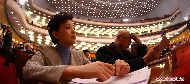 Yang Lan (L), a member of the 11th National Committee of the Chinese People's Political Consultative Conference (CPPCC), attends the Fifth Session of the 11th CPPCC National Committee at the Great Hall of the People in Beijing, capital of China, March 3, 2012.