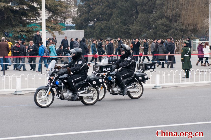 Police with the SWAT unit patrol the roads surrounding the Great Hall of the People shortly before the opening ceremony of CPPCC takes place on Saturday afternoon. [China.org.cn]