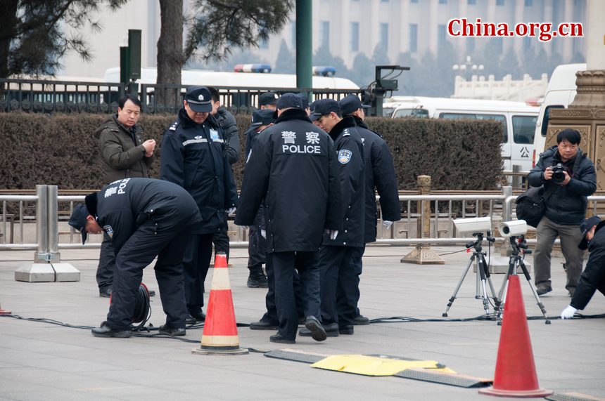 Police set up surveillance cameras on the path leading to the parking area for journalists' vehicles shortly before the CPPCC opens its annual session at the Great Hall of the People in Beijing on Saturday afternoon. [China.org.cn]