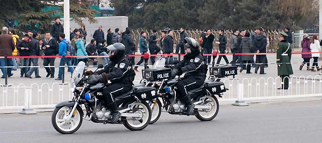 Police with the SWAT unit patrol the roads surrounding the Great Hall of the People shortly before the opening ceremony of CPPCC takes place on Saturday afternoon.