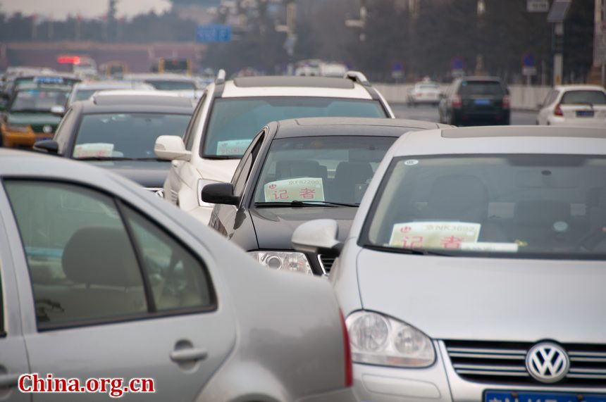 Journalists' vehicles queue up at the east side of the Tian'anmen Square for security check before entering the parking section at the square. They come to report the opening ceremony of CPPCC which starts on Saturday afternoon in Beijing. [China.org.cn]