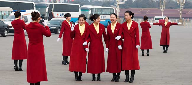 Hotel staff members serving the delegations to the National People's Congress (NPC) pose for photos at the Tian'anmen Square on Sunday, March 4, 2012, in Beijing, China, one day prior to the NPC's opening ceremony on the morning of March 5 at the Great Hall of the People.