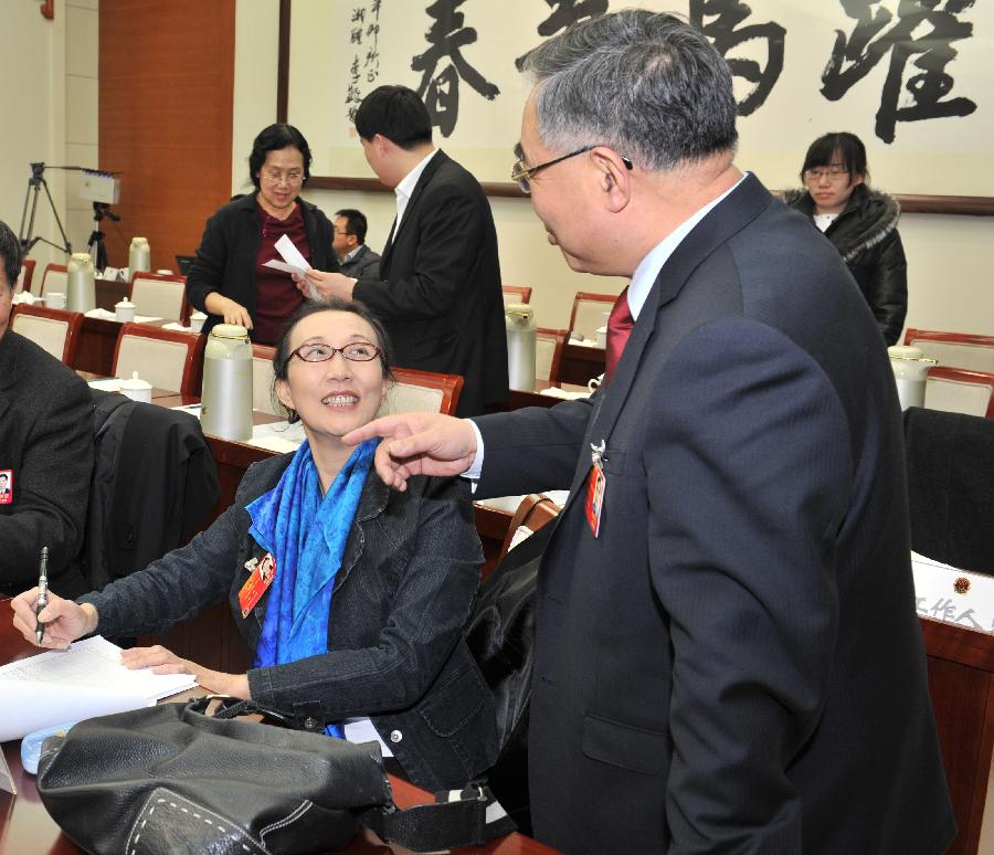 Zhang Boli (R), a deputy to the Fifth Session of the 11th National People's Congress (NPC) talks to deputy Zhao Mei on his suggestions. Deputies to the NPC session from Tianjin Municipality had a group discussion on Monday.