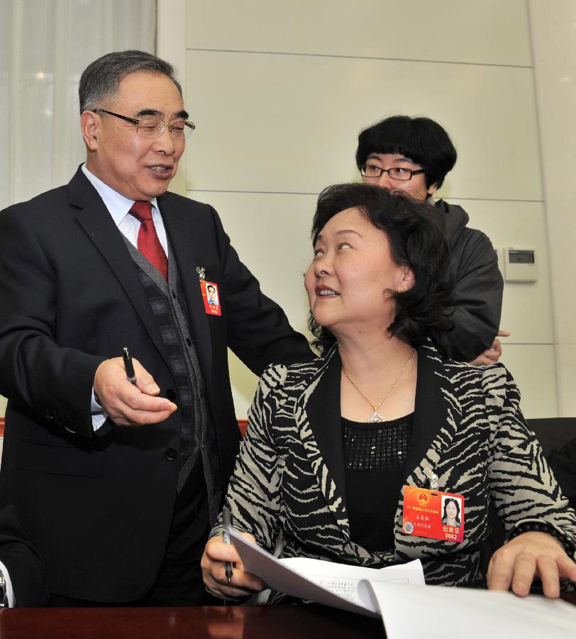 Zhang Boli (L), a deputy to the Fifth Session of the 11th National People's Congress (NPC) talks to deputy Wang Aijian on his suggestions. Deputies to the NPC session from Tianjin Municipality had a group discussion on Monday.