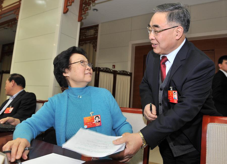 Zhang Boli (R), a deputy to the Fifth Session of the 11th National People's Congress (NPC) talks to deputy Zhu Tianhui on his suggestions. Deputies to the NPC session from Tianjin Municipality had a group discussion on Monday. 