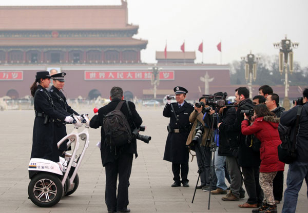 Two police officers riding two-wheeled patrol scooters became the focus of the media after the opening ceremony of the fifth session of the 11th CPPCC National Committee in Beijing, March 3, 2012. 