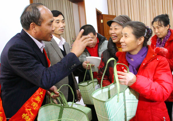 NPC Deputy Chen Fei (left) presents bamboo baskets to representatives from the Women and Children Social Service Center in Beijing on Sunday. 
