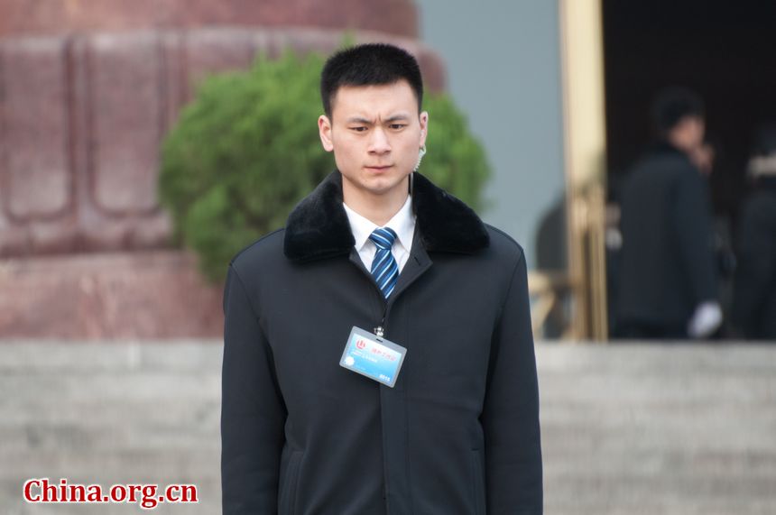 A security officer stands on duty at the entrance to the Great Hall of the People in Beijing, China, on Sunday, March 4, 2012 as delegates to the congress and journalists covering the events queue to enter the venue. [China.org.cn]