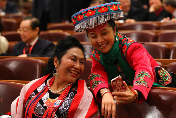 Two members of the Chinese People&apos;s Political Consultative Conference National Committee capture the memeries with a mobile phone at the opening ceremony of this year&apos;s session in Beijing, March 3, 2012. 