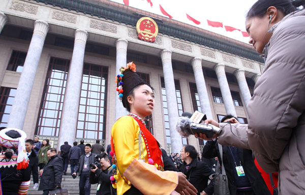 Liang Xiaodan, an ethnic group member of the Chinese People&apos;s Political Consultative Conference National Committee is interviewed prior to the opening ceremony of this year&apos;s session in Beijing, March 3, 2011. 