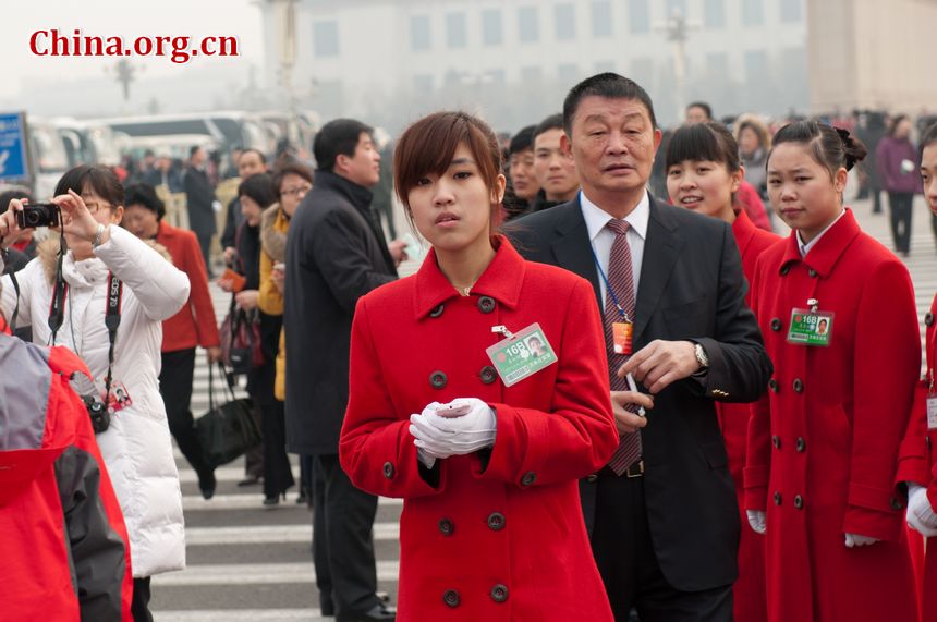 Staff workers from the hotels that host the delegates to the 11th National People&apos;s Congress (NPC) beam at the lens amid the opening ceremony of the the Congress&apos; fifth annual session. [China.org.cn]