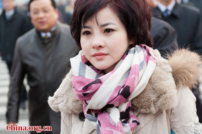 A neatly dressed woman with the staff walks into the Great Hall of the People on Monday, March 5, 2012, as the annual session of China&apos;s National People&apos;s Congress starts. [China.org.cn]