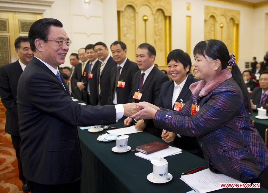 He Guoqiang (L, front), who is a member of the Standing Committee of the Political Bureau of the Communist Party of China (CPC) Central Committee and secretary of the CPC Central Commission for Discipline Inspection, visits deputies to the Fifth Session of the 11th National People's Congress (NPC) from south China's Guangdong Province and joins their panel discussion in Beijing, capital of China, March 7, 2012. 