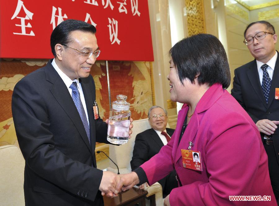 Chinese Vice Premier Li Keqiang (L), who is also a member of the Standing Committee of the Political Bureau of the Communist Party of China (CPC) Central Committee, visits deputies to the Fifth Session of the 11th National People's Congress (NPC) from central China's Hubei Province and joins their panel discussion in Beijing, capital of China, March 7, 2012.