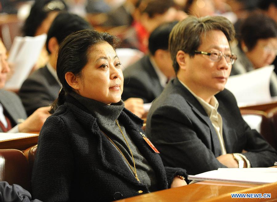 Ni Ping (L), a television host and a member of the 11th National Committee of the Chinese People's Political Consultative Conference (CPPCC), attends the second plenary meeting of the Fifth Session of the 11th CPPCC National Committee at the Great Hall of the People in Beijing, capital of China, March 9, 2012.