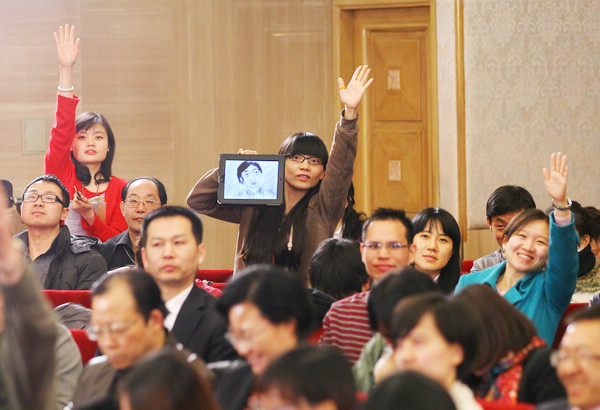 A reporter uses a novel approach to attract Feng Jicai, a renowned writer and Chinese People's Political Consultative Conference National Committee member, by holding a sketch of him during a news conference on cultural reform in Beijing on Thursday. 