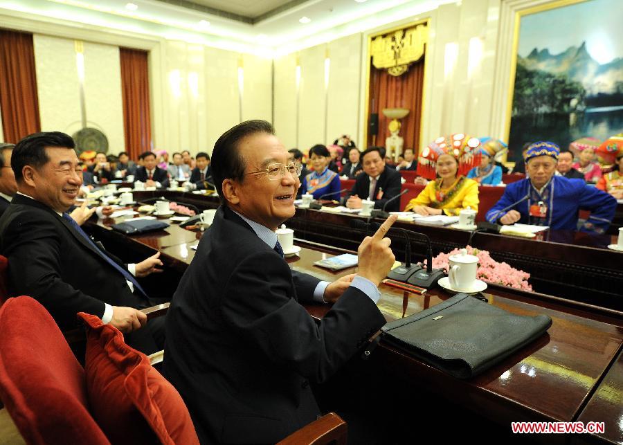 Chinese Premier Wen Jiabao (R, front), who is also a member of the Standing Committee of the Political Bureau of the Communist Party of China (CPC) Central Committee, visits deputies to the Fifth Session of the 11th National People&apos;s Congress (NPC) from south China&apos;s Guangxi Zhuang Autonomous Region and joins their panel discussion in Beijing, capital of China, March 9, 2012.