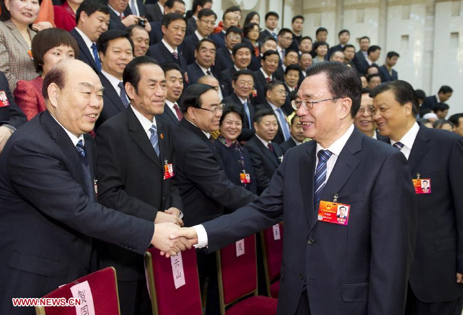 He Guoqiang (R, front), member of the Standing Committee of the Political Bureau of the Communist Party of China (CPC) Central Committee and secretary of the CPC Central Commission for Discipline Inspection, visits deputies to the Fifth Session of the 11th National People's Congress (NPC) from central China's Henan Province and joins their panel discussion in Beijing, capital of China, March 9, 2012.