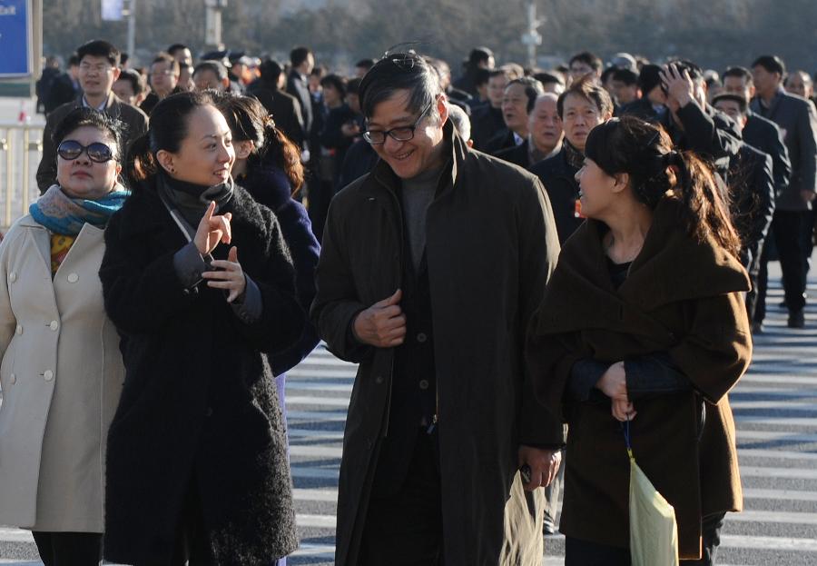 Tai Lihua (2nd L), a member of the 11th National Committee of the Chinese People's Political Consultative Conference (CPPCC), communicates with other members with the help of a sign language interpreter prior to the fourth plenary meeting of the Fifth Session of the 11th CPPCC National Committee outside the Great Hall of the People in Beijing, capital of China, March 11, 2012. \