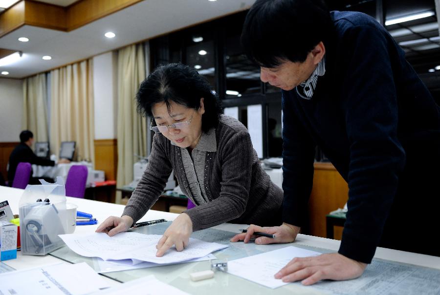 (Hu Zhigang (R) and Zhang Yuhuan work at the bulletin group of the secretariat of the Fifth Session of the 11th National People&apos;s Congress (NPC) in Beijing, capital of China, March 11, 2012.