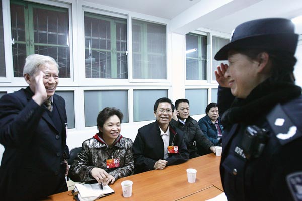National People's Congress deputy Yang Shengchuan (left) greets a police officer in Fusuijing community in Beijing's Xicheng district. Yang, together with three other NPC deputies, visited police officers on duty in the district.