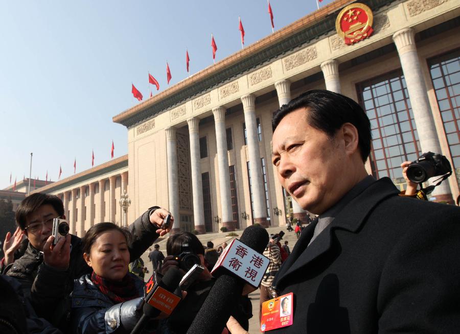 Wang Guoxin, a member of the 11th National Committee of the Chinese People's Political Consultative Conference (CPPCC), speaks to journalists outside the Great Hall of the People after the closing meeting of the Fifth Session of the 11th CPPCC National Committee in Beijing, capital of China, March 13, 2012.