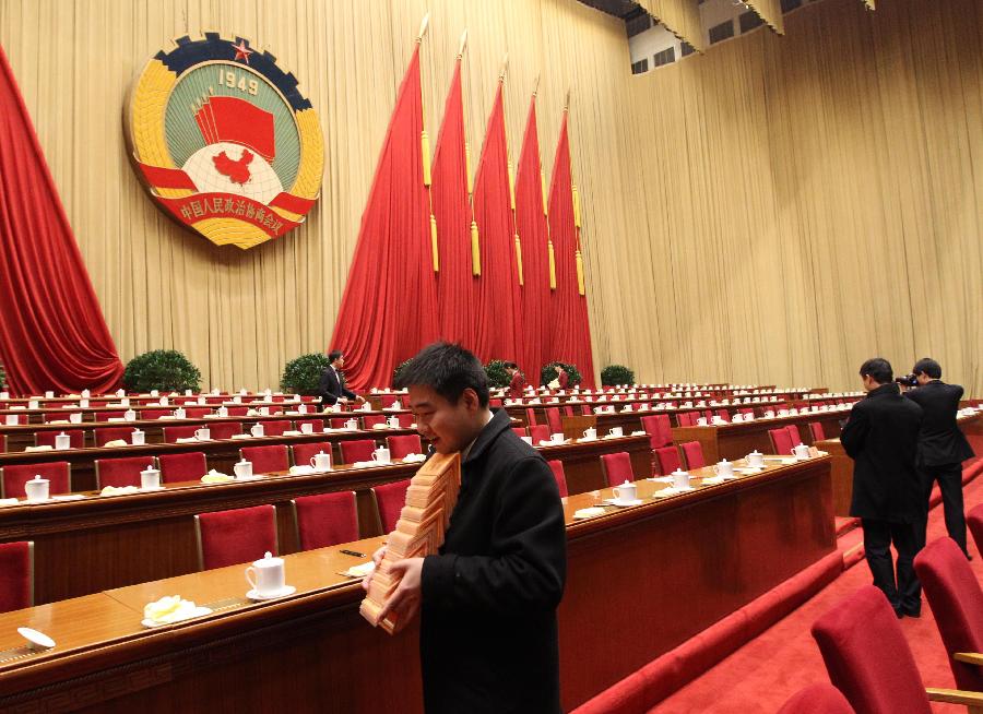 Staff members clean up the conference hall after the closing meeting of the Fifth Session of the 11th National Committee of the Chinese People's Political Consultative Conference (CPPCC) at the Great Hall of the People in Beijing, capital of China, March 13, 2012. 