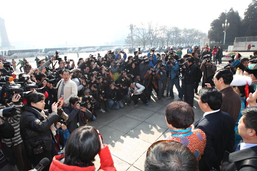 Journalists take photos for members of the 11th National Committee of the Chinese People's Political Consultative Conference (CPPCC) outside the Great Hall of the People after the closing meeting of the Fifth Session of the 11th CPPCC National Committee in Beijing, capital of China, March 13, 2012. 