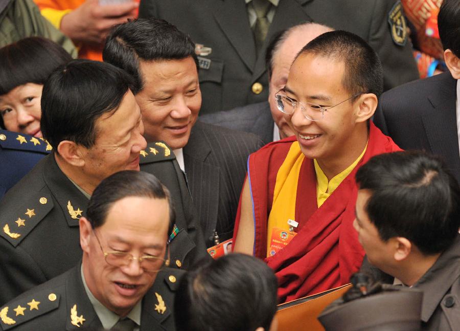 The 11th Panchen Lama Bainqen Erdini Qoigyijabu, also a member of the 11th National Committee of the Chinese People's Political Consultative Conference (CPPCC), talks to other members after the closing meeting of the Fifth Session of the 11th CPPCC National Committee in Beijing, capital of China, March 13, 2012.