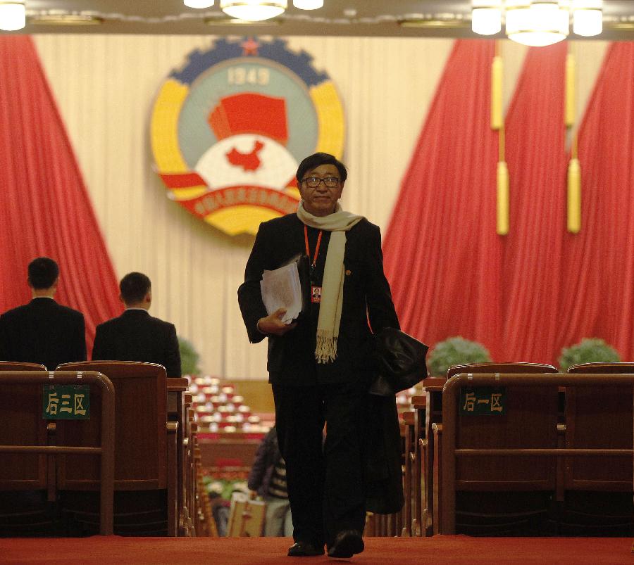 A member of the 11th National Committee of the Chinese People's Political Consultative Conference (CPPCC) leaves the conference hall in the Great Hall of the People after the closing meeting of the Fifth Session of the 11th CPPCC National Committee in Beijing, capital of China, March 13, 2012.