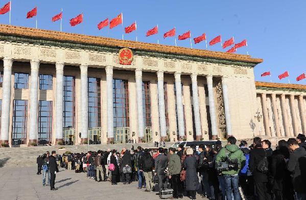 Journalists wait in queues to enter the Great Hall of the People in Beijing, capital of China, March 14, 2012. 